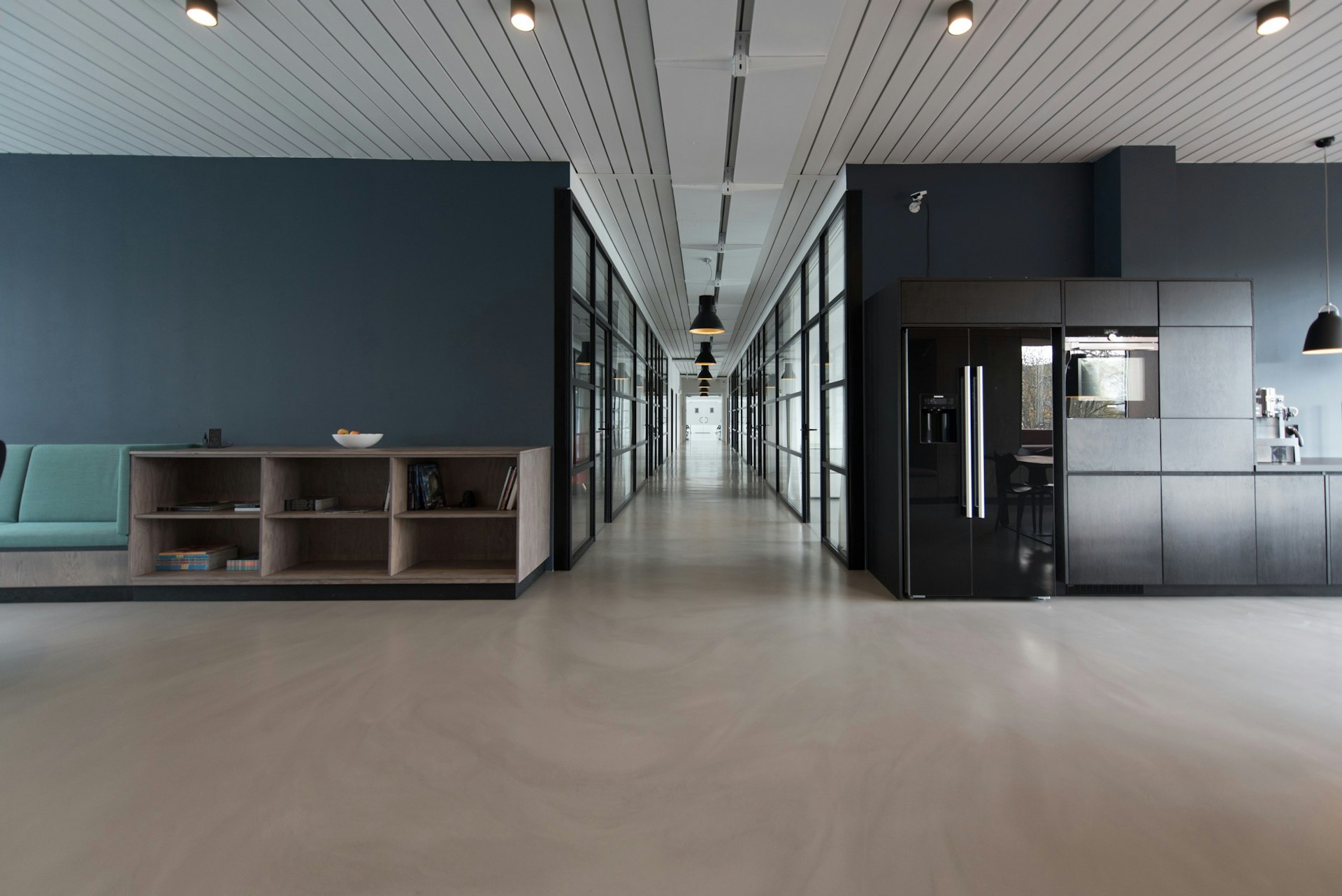 Glass-walled office corridor and shared workspace
